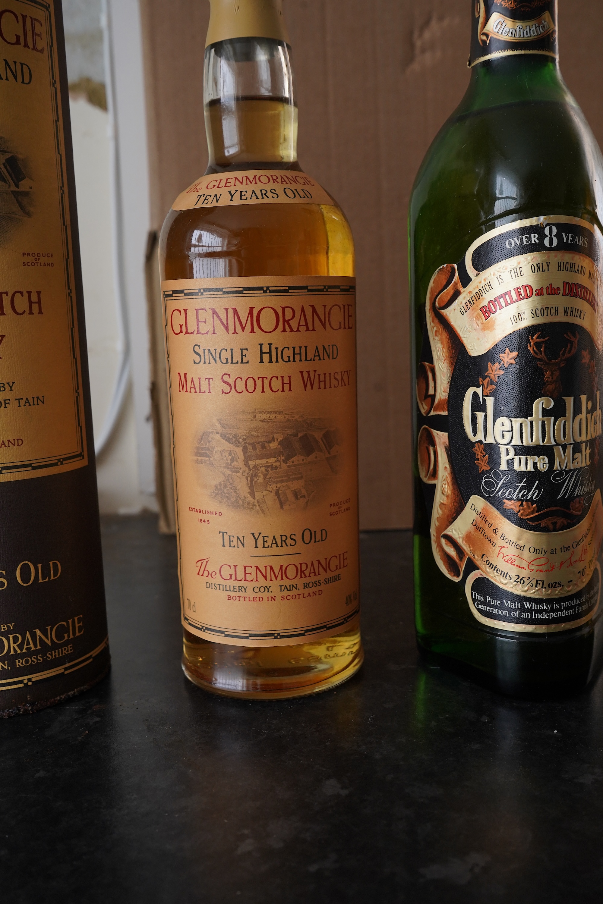 Three bottles of malt whisky: Glenmorangie, Glenfiddich and Grants